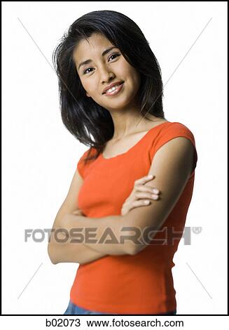 Stock Image - Portrait of a young woman standing with her arms folded. Fotosearch