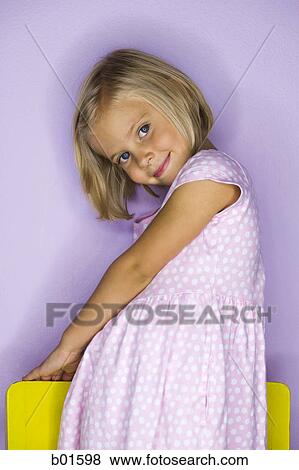 Stock Photo - Portrait of a girl standing on a chair. Fotosearch