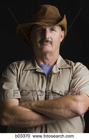 Portrait of a mature man standing with his arms crossed View Large Photo Image Stock Image - Portrait of a mature man standing with his arms crossed. Fotosearch