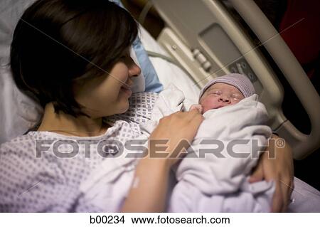 Close-up of a mother carrying her newborn baby View Large Photo Image Picture - Close-up of a mother carrying her newborn baby. Fotosearch