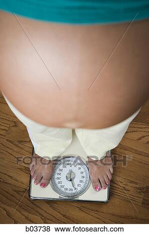 Stock Photo - Portrait of a young woman standing with her arms crossed. Fotosearch