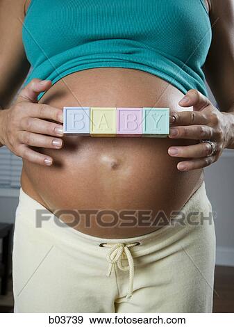 Portrait of a young woman standing with her arms crossed View Large Photo Image Stock Photo - Portrait of a young woman standing with her arms crossed. Fotosearch