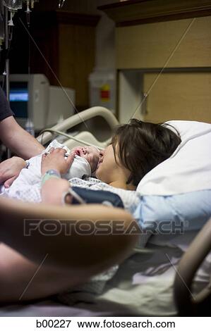 Side profile of a mother lying with her newborn baby girl on a bed View Large Photo Image Stock Photo - Side profile of a mother lying with her newborn baby girl on a bed. Fotosearch