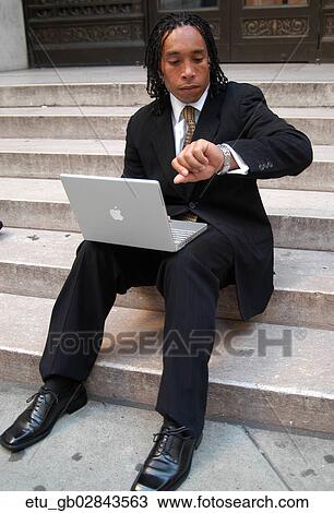 Stock Image - Business, Outside, African American, Watch, Time. Fotosearch