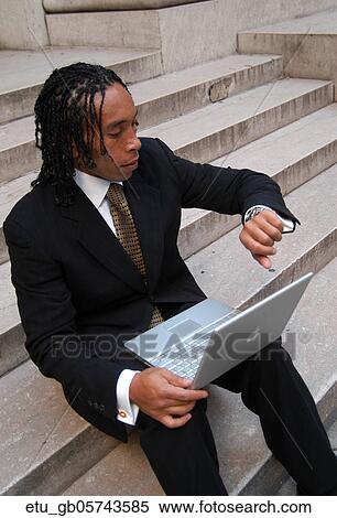 Stock Photography - Business, Outside, African American, Watch, Time. Fotosearch