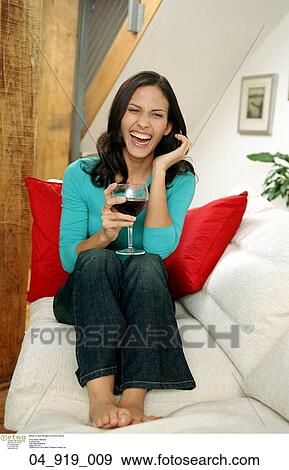 Stock Photo - Happy, Woman, Inside, Laughing, Relaxing, Drinking, alcohol. Fotosearch