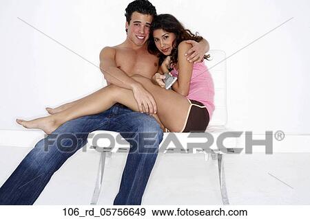 Stock Photo - TV, Topless, Television, Technology, Shorts, Remote, Relationships. Fotosearch