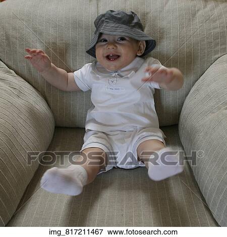 Stock Photo - White, shirt, socks, sitting, Infant, hat, chair. Fotosearch