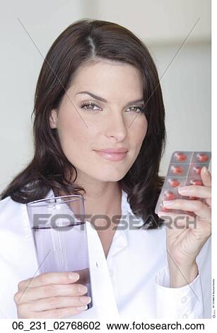 Stock Image - woman, glass, water, pills. Fotosearch