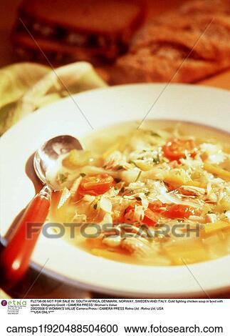 Stock Image - Cold fighting chicken soup in bowl with spoon. Fotosearch