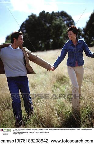 Stock Image - Couple, outdoors, walking, holding hands. Fotosearch