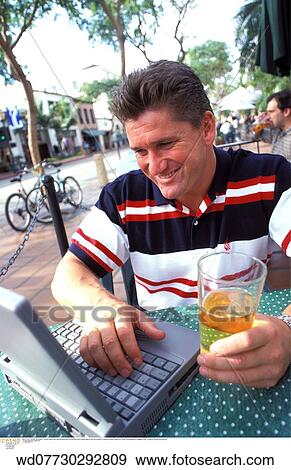 Stock Photo - technology, working on holiday, typing, vertical image, workaholic, summer, abroad. Fotosearch