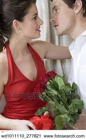 Stock Image - twenties, vertical image, under 35, Valentines, Valentines present, touching, at home. Fotosearch