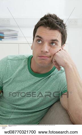 Stock Image - unhappy, thinking, thoughtful, under 35, at home. Fotosearch