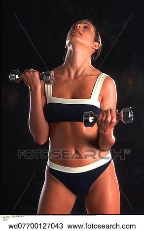 Stock Image - using weights, under 35, studio, solo. Fotosearch