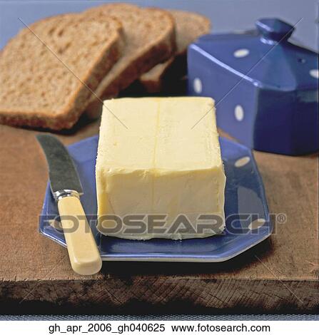 A block of butter on blue plate with knife on the side. Brown bread in the background. View Large Photo Image Stock Photography - A block of butter on blue plate with knife on the side. Brown bread in the background.. Fotosearch