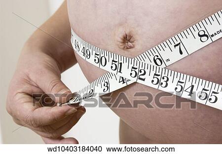 Anonymous cropped shot of a heavily pregnant female holding a measuring tape around her belly. View Large Photo Image Stock Image - Anonymous cropped shot of a heavily pregnant female holding a measuring tape around her belly.. Fotosearch