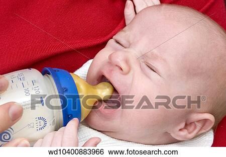 Stock Photograph - Close up of a baby wearing a white bib. Fotosearch