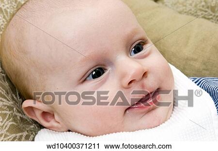 Stock Image - Close up of a baby's smiling face.. Fotosearch