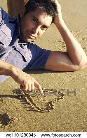 Stock Image - Cropped image of brunette male wearing a blue short sleeved shirt. Fotosearch