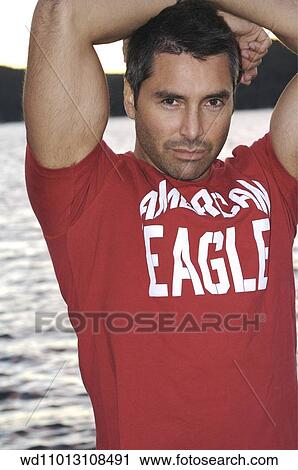 Cropped image of brunette male wearing a red logo T shirt View Large Photo Image Stock Image - Cropped image of brunette male wearing a red logo T shirt. Fotosearch