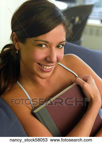 Ethnic Girl wearing a blue tank top sits in her apartment enjoying a book for relaxation. View Large Photo Image Stock Image - Ethnic Girl wearing a blue tank top sits in her apartment enjoying a book for relaxation.. Fotosearch