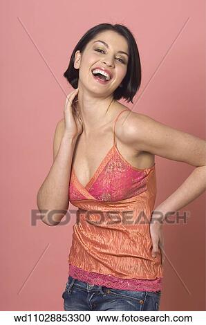 Female with straight brunette hair wearing orange and pink crumpled silk camisole with lace detail and blue jeans hand on back and to neck throwing head back looking to camera mouth open smiling showing teeth. View Large Photo Image Stock Image - Female with straight brunette hair wearing orange and pink crumpled silk camisole with lace detail and blue jeans hand on back and to neck throwing head back looking to camera mouth open smiling showing teeth.. Fotosearch