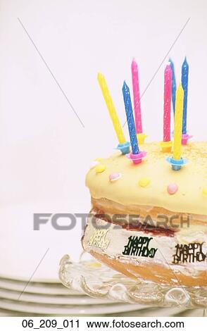 Stock Image - Food still life cake candles candle birthday plates dessert yellow sweet sweets. Fotosearch