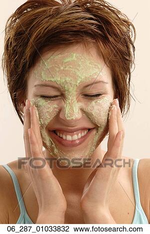 Front view head and shoulders young woman with short hair applying a face mask with eyes closed laughing View Large Photo Image Stock Image - Front view head and shoulders young woman with short hair applying a face mask with eyes closed laughing. Fotosearch