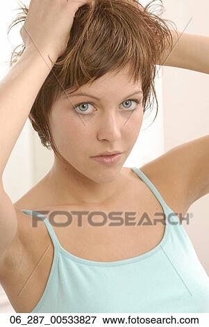 Front view head and shoulders young woman looking at camera with her hands in her hair View Large Photo Image Stock Photo - Front view head and shoulders young woman looking at camera with her hands in her hair. Fotosearch