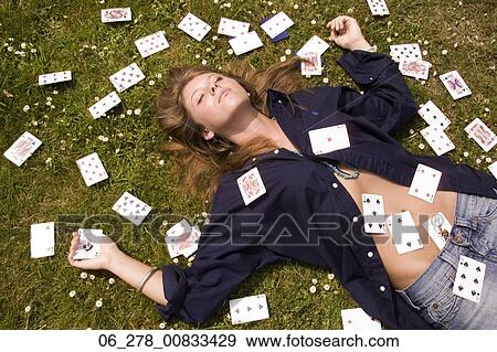 Half length above front view young woman long blonde hair lying eyes closed on grass covered in playing cards View Large Photo Image Stock Photo - Half length above front view young woman long blonde hair lying eyes closed on grass covered in playing cards. Fotosearch
