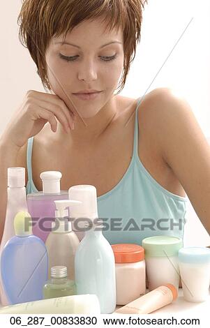 Half length front view of young woman with short hair leaning on elbows looking down at beauty products View Large Photo Image Stock Image - Half length front view of young woman with short hair leaning on elbows looking down at beauty products. Fotosearch