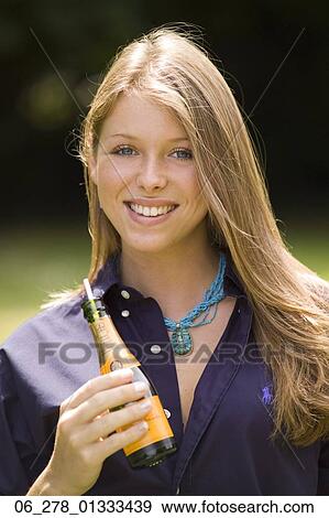 Half length front view young woman long blonde hair holding a bottle looking at camera smiling View Large Photo Image Stock Photo - Half length front view young woman long blonde hair holding a bottle looking at camera smiling. Fotosearch