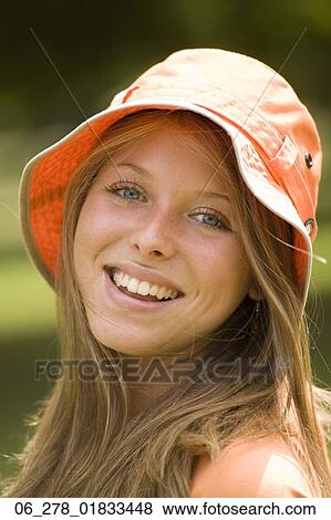 Head and shoulders side view portrait young blonde woman in a rain hat looking at camera smiling View Large Photo Image Stock Photo - Head and shoulders side view portrait young blonde woman in a rain hat looking at camera smiling. Fotosearch