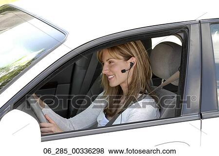 Head and shoulders side view woman sitting in drivers seat wearing an earphone View Large Photo Image Stock Photo - Head and shoulders side view woman sitting in drivers seat wearing an earphone. Fotosearch