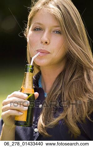 Head and shoulders side view young woman long blonde hair drinking from a bottle looking at camera smiling View Large Photo Image Stock Image - Head and shoulders side view young woman long blonde hair drinking from a bottle looking at camera smiling. Fotosearch