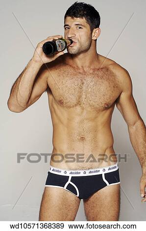 Stock Photo - Male wearing black underpants drinking from a bottle of beer and looking to camera.. Fotosearch