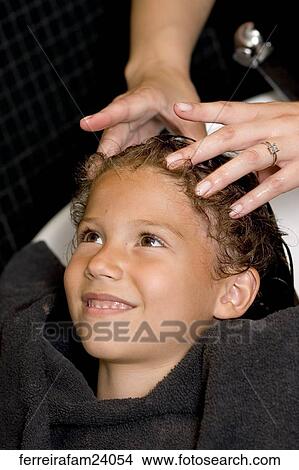 A young girl having her hair washed at a salon. View Large Photo Image Picture - A young girl having her hair washed at a salon.. Fotosearch