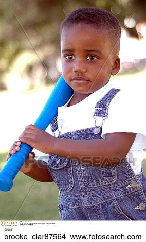 African American little boy playing baseball outside in denim jump suit View Large Photo Image Picture - African American little boy playing baseball outside in denim jump suit. Fotosearch