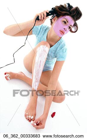 Beauty careWoman with purple face mask and shaving foam on her leg painting her toenails red whilst styling her hair View Large Photo Image Stock Image - Beauty careWoman with purple face mask and shaving foam on her leg painting her toenails red whilst styling her hair . Fotosearch