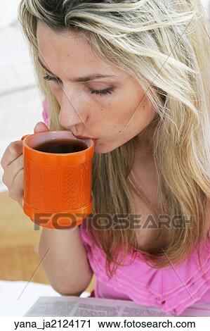 Blonde woman in her 20's drinking a cup of coffee from an orange mug. View Large Photo Image Stock Image - Blonde woman in her 20's drinking a cup of coffee from an orange mug. . Fotosearch