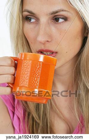 Blonde woman in her 20's drinking a cup of coffee from an orange mug. View Large Photo Image Stock Photo - Blonde woman in her 20's drinking a cup of coffee from an orange mug. . Fotosearch