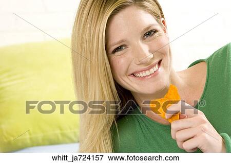 Blonde woman in her 20's eats potato chips View Large Photo Image Stock Photo - Blonde woman in her 20's eats potato chips. Fotosearch