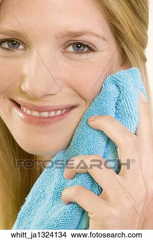 Blonde woman in her 20's holds a blue towel to her face View Large Photo Image Picture - Blonde woman in her 20's holds a blue towel to her face. Fotosearch