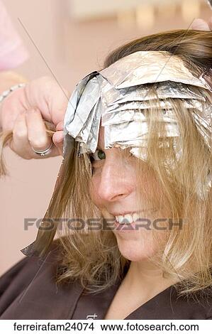 Blonde woman in her 30's having her hair colored in a salon. View Large Photo Image Picture - Blonde woman in her 30's having her hair colored in a salon.. Fotosearch