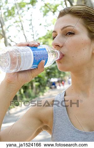 Brunette woman drinking water outside. View Large Photo Image Stock Photograph - Brunette woman drinking water outside.. Fotosearch