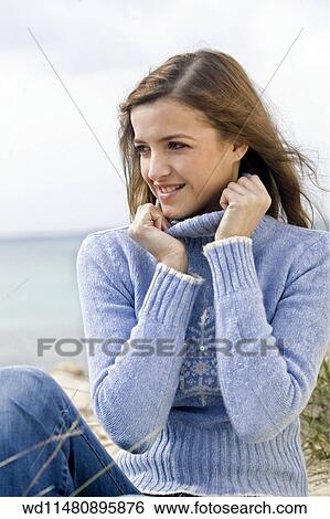 Female With Long Blonde Hair Wearing Pale Blue Poloneck Jumper And