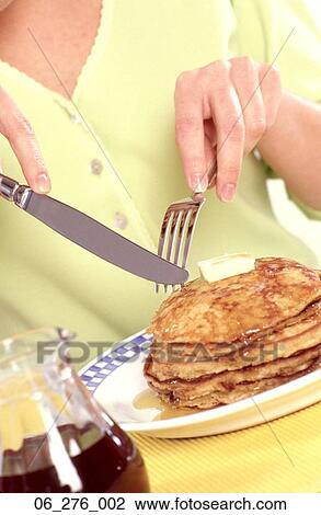 Stock Image -  FoodWoman eating pancakes . Fotosearch