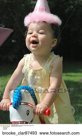 Little girl african american wearing birthday hat happy playing on rocking horse View Large Photo Image Stock Image - Little girl african american wearing birthday hat happy playing on rocking horse. Fotosearch