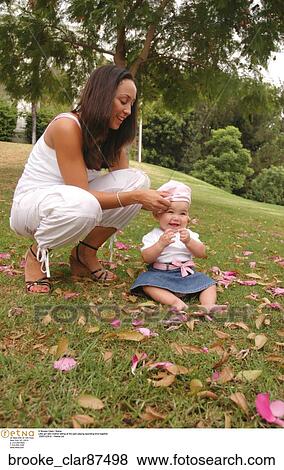 Little girl latin mother sitting at the park playing spending time together View Large Photo Image Stock Photo - Little girl latin mother sitting at the park playing spending time together. Fotosearch